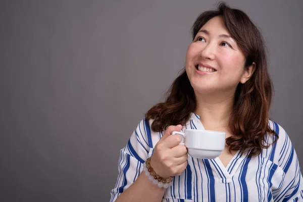 Madura hermosa mujer de negocios asiática sosteniendo taza de café —  Fotos de Stock