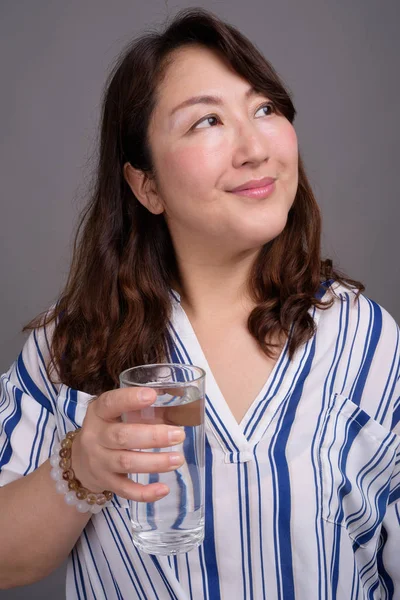물 잔을 들고 성숙한 아름 다운 아시아 사업가 — 스톡 사진