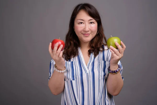 Madura hermosa mujer de negocios asiática sosteniendo manzana saludable — Foto de Stock