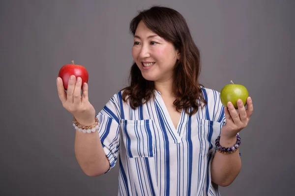 Madura hermosa mujer de negocios asiática sosteniendo manzana saludable — Foto de Stock