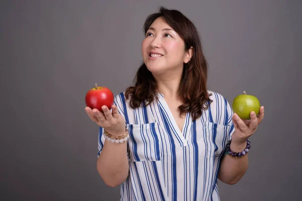 Madura hermosa mujer de negocios asiática sosteniendo manzana saludable — Foto de Stock