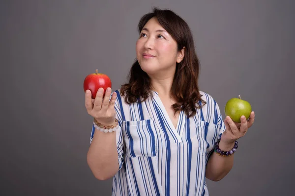 Madura hermosa mujer de negocios asiática sosteniendo manzana saludable —  Fotos de Stock