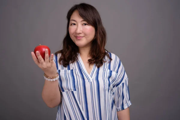 Madura hermosa mujer de negocios asiática sosteniendo manzana saludable — Foto de Stock