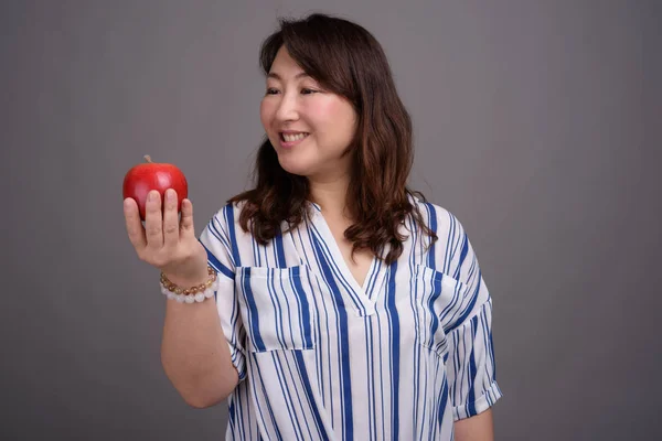 Madura hermosa mujer de negocios asiática sosteniendo manzana saludable — Foto de Stock