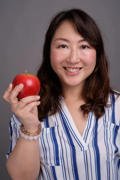 Madura hermosa mujer de negocios asiática sosteniendo manzana saludable — Foto de Stock