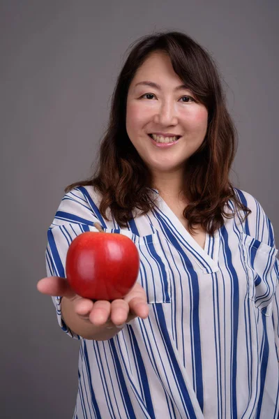 Madura hermosa mujer de negocios asiática sosteniendo manzana saludable — Foto de Stock