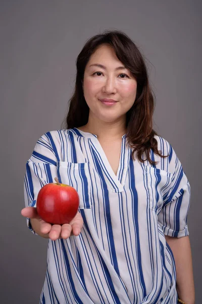 Madura hermosa mujer de negocios asiática sosteniendo manzana saludable — Foto de Stock