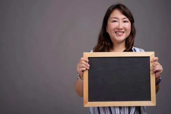 Asian businesswoman holding blackboard with copy space — Stock Photo, Image
