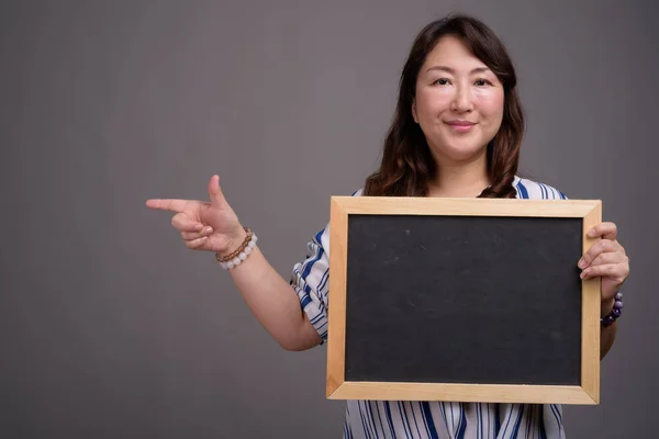 Азиатская бизнесвумен держит доску с копировальным пространством — стоковое фото