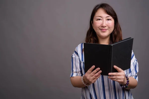 Ritratto di bella donna d'affari asiatica matura libro di lettura — Foto Stock