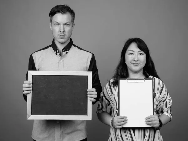 Portrait de couple multiethnique diversifié en studio montrant l'espace de copie — Photo