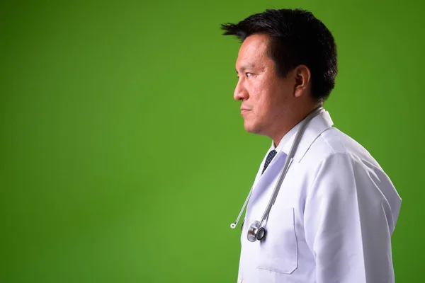 Maduro japonés hombre médico contra verde fondo —  Fotos de Stock