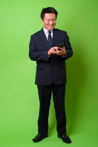 Maduro japonés hombre de negocios contra fondo verde —  Fotos de Stock