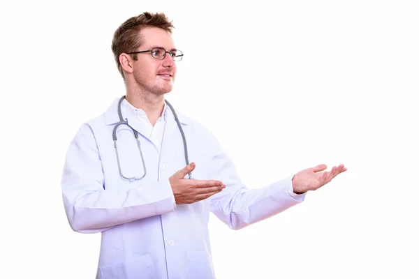 Estudio de tiro de hombre feliz médico sonriendo mientras muestra algo —  Fotos de Stock