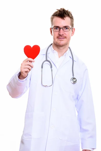 Estúdio tiro de homem feliz médico sorrindo enquanto segurando coração vermelho — Fotografia de Stock