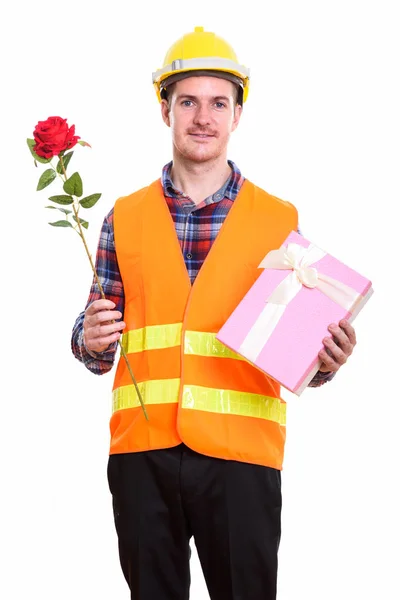 Glücklicher Mann Bauarbeiter lächelt, während er rote Rose und — Stockfoto