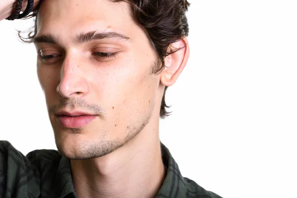 Close up de homem bonito jovem escovar o cabelo para trás enquanto pensa — Fotografia de Stock