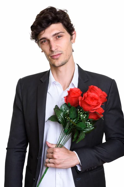 Studio ditembak muda tampan pengusaha memegang mawar merah — Stok Foto