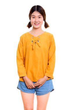 Gülümseyen Asyalı genç bir kadının stüdyo fotoğrafı.