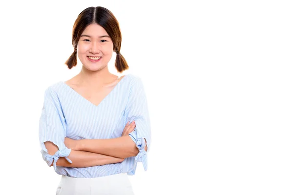 Studio shot van jong gelukkig aziatisch vrouw glimlachen met armen gekruist — Stockfoto