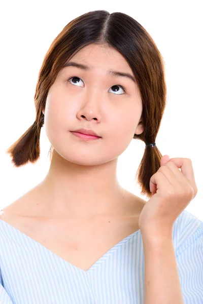 Cara de joven hermosa mujer asiática pensando mientras mira hacia arriba — Foto de Stock