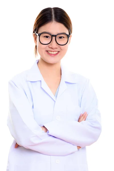 Studio plan de jeune femme asiatique heureuse médecin souriant avec les bras — Photo