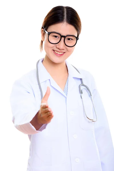 Studio shot of young happy Asian woman doctor smiling while givi — Stock Photo, Image