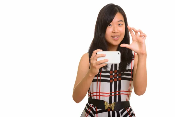 Young happy Asian businesswoman focusing while taking picture wi — Stock Photo, Image