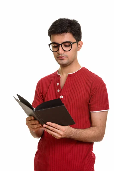 Portrait of young handsome Persian man reading book — Stock Photo, Image