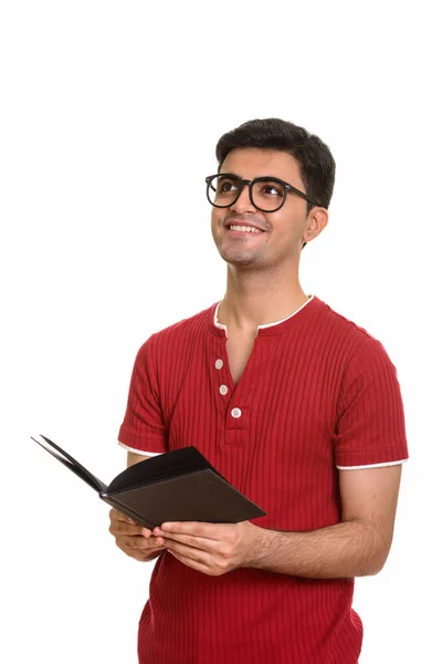 Fiatal boldog perzsa férfi kezében könyv, miközben gondolkodás — Stock Fotó