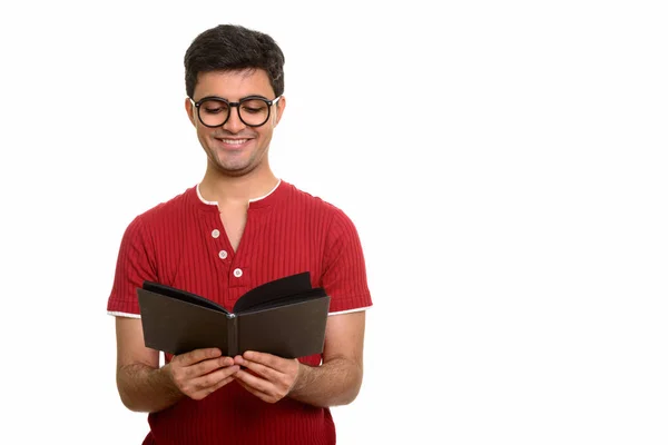 Молодой счастливый перс читает книгу, улыбаясь — стоковое фото