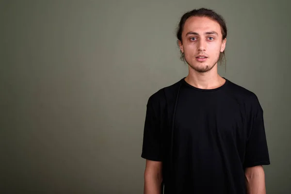 Jovem homem bonito vestindo camisa preta contra backgroun colorido — Fotografia de Stock