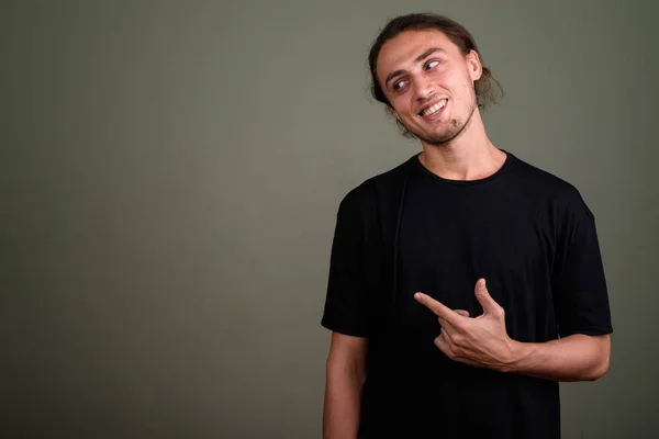 Jovem homem bonito vestindo camisa preta contra backgroun colorido — Fotografia de Stock