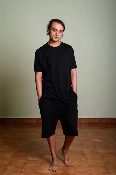 Jonge knappe man dragen zwart shirt tegen gekleurde pagina — Stockfoto