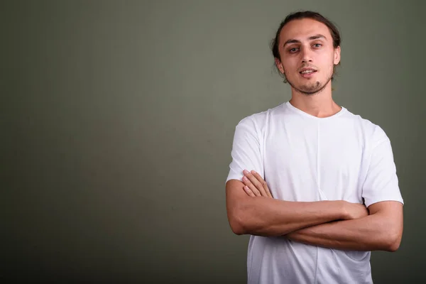 Jovem homem bonito vestindo camisa branca contra backgroun colorido — Fotografia de Stock