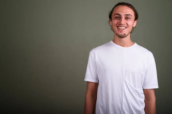 Jovem homem bonito vestindo camisa branca contra backgroun colorido — Fotografia de Stock