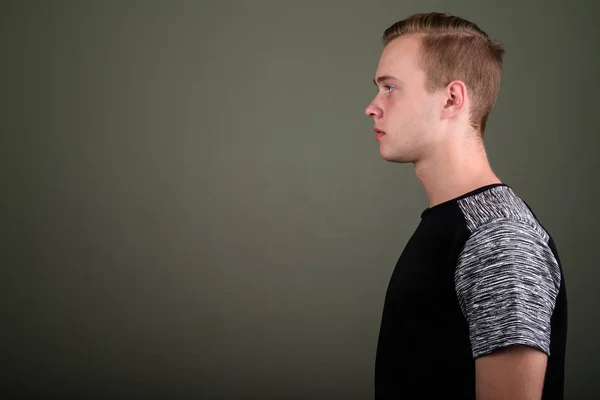 Jovem homem bonito com cabelo loiro contra fundo colorido — Fotografia de Stock