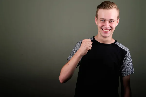 Junger schöner Mann mit blonden Haaren vor farbigem Hintergrund — Stockfoto