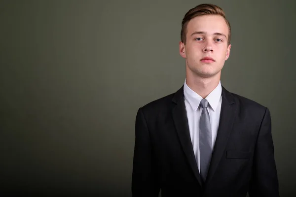 Jonge knappe zakenman dragen pak tegen gekleurde CHTERGRO — Stockfoto