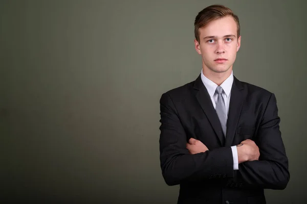 Jonge knappe zakenman dragen pak tegen gekleurde CHTERGRO — Stockfoto