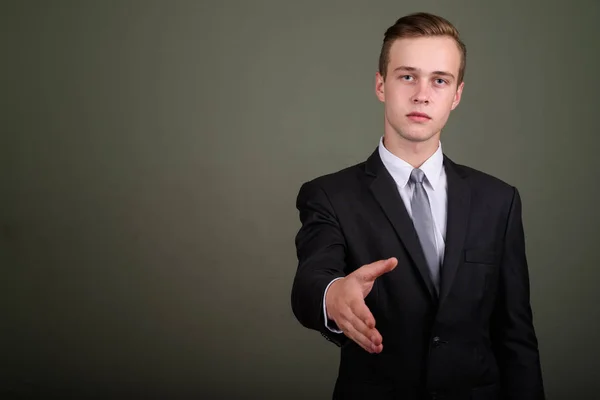 Jonge knappe zakenman dragen pak tegen gekleurde CHTERGRO — Stockfoto