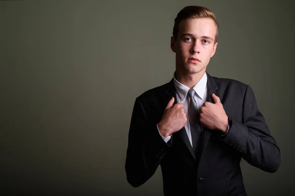 Jonge knappe zakenman dragen pak tegen gekleurde CHTERGRO — Stockfoto