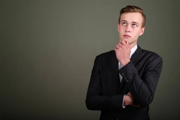 Молодой привлекательный бизнесмен в костюме против цветной задницы — стоковое фото