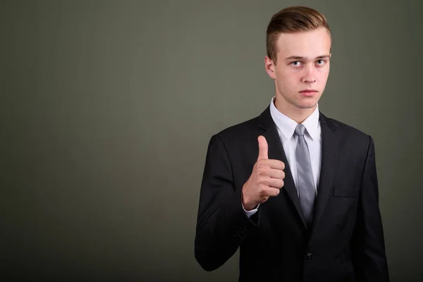 Jonge knappe zakenman dragen pak tegen gekleurde CHTERGRO — Stockfoto