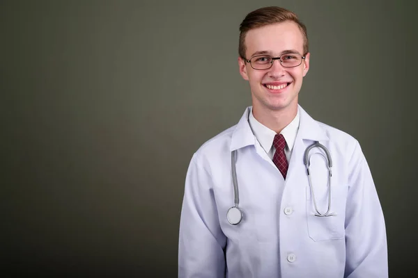 Joven hombre guapo médico contra el fondo de color —  Fotos de Stock