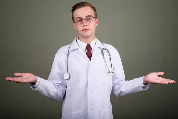 Jovem bonito homem médico contra fundo colorido — Fotografia de Stock