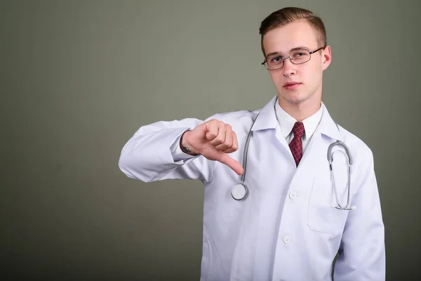 Giovane bello uomo medico contro sfondo colorato — Foto Stock