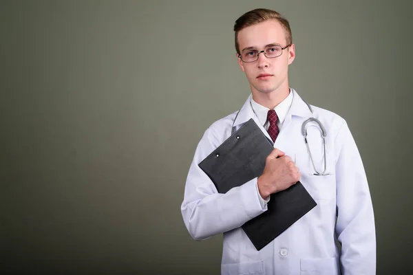 Молодий красивий лікар на кольоровому фоні — стокове фото
