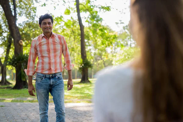 Hombre indio feliz sonriendo y de pie mientras mira hermosa — Foto de Stock