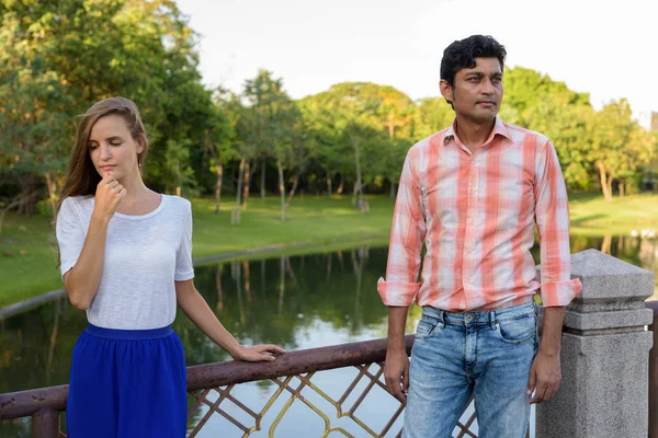 Multi casal étnico pensando enquanto olha triste na ponte de — Fotografia de Stock